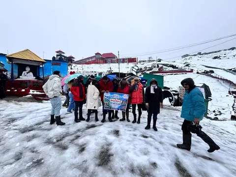 Easy Way Holidays tour group standing in snow near mountain buildings
