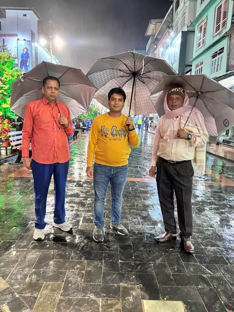 Travellers with umbrellas on a rainy street during a group trip
