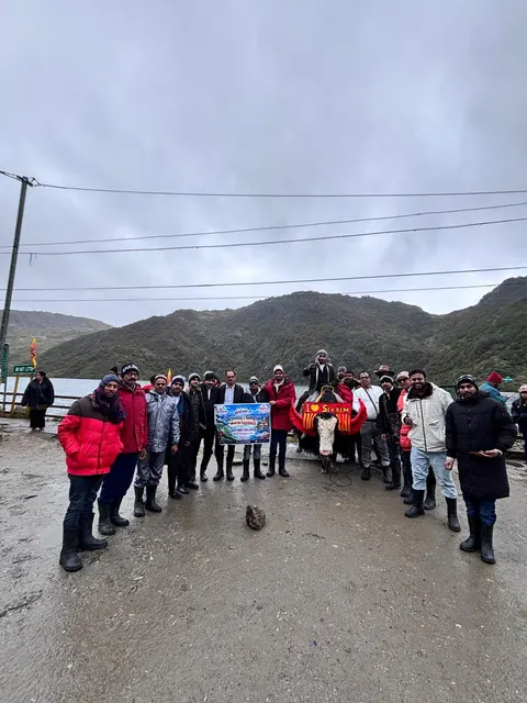 Travellers gathered on a mountain roadside beneath a cloudy sky