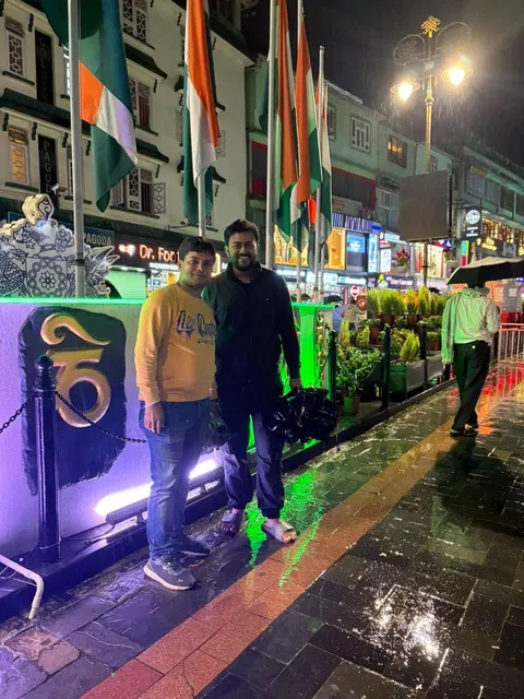 Traveller standing beside a brightly lit train at night