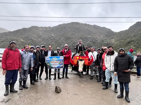 Easy Way Holidays group holding a tour banner beside a mountain road