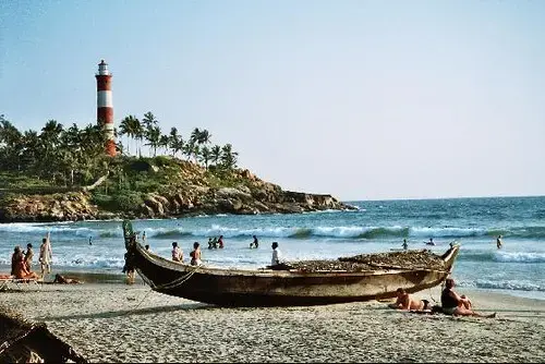 Coastal lighthouse above a palm-fringed beach near Trivandrum